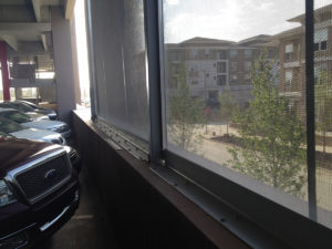 Looking out of facade from the interior of a parking garage.